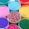A collection of brightly colored frosted glass rice beads in various shades including blue, pink, yellow, purple, and green.
