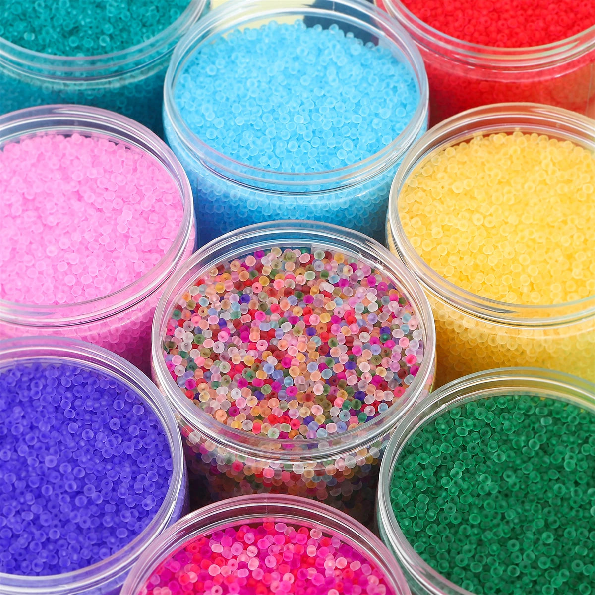 A collection of brightly colored frosted glass rice beads in various shades including blue, pink, yellow, purple, and green.