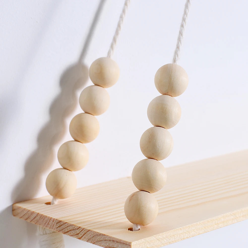 A pair of natural wooden beads hanging on a white string against a light background.