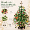 Handcrafted beaded details on a festive green Christmas tree with colorful ornaments and angel topper