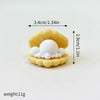 A set of yellow cake toppers shaped like a whale, octopus, and turtle, with a white ball centerpiece.