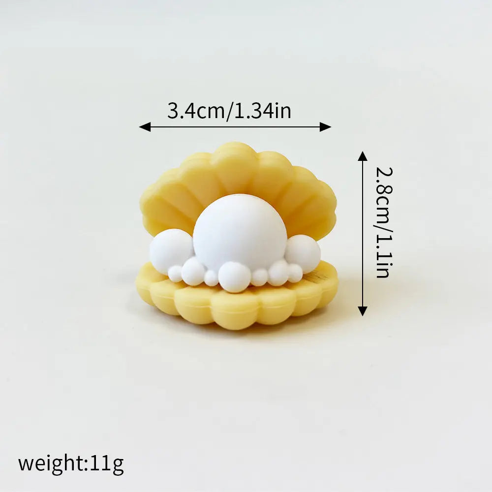 A set of yellow cake toppers shaped like a whale, octopus, and turtle, with a white ball centerpiece.