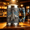 Una taza de café plateada con temática militar y diseño de la Fuerza Aérea sobre una mesa de madera.