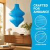 A bright blue, handcrafted paper lantern with a sturdy frame is displayed in a modern interior setting.