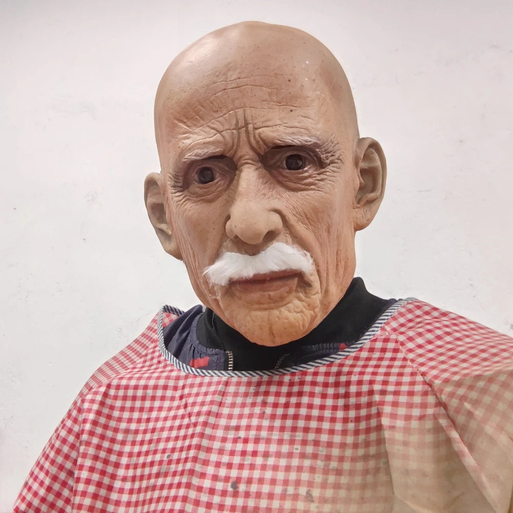 A realistic latex mask of an old man with a bald head, white mustache, and wrinkled skin.