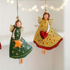 A set of four vintage wood angel Christmas tree ornaments hanging on a string against a light background.