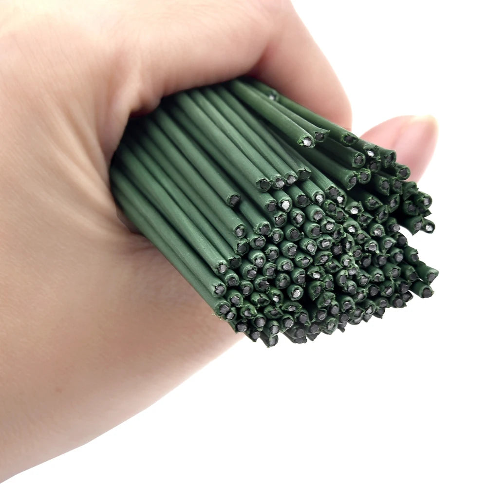 A hand holds a bundle of artificial green flower stems for DIY floral decor.
