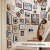 A set of five black wooden picture frames displayed on a light-colored wall above a staircase.
