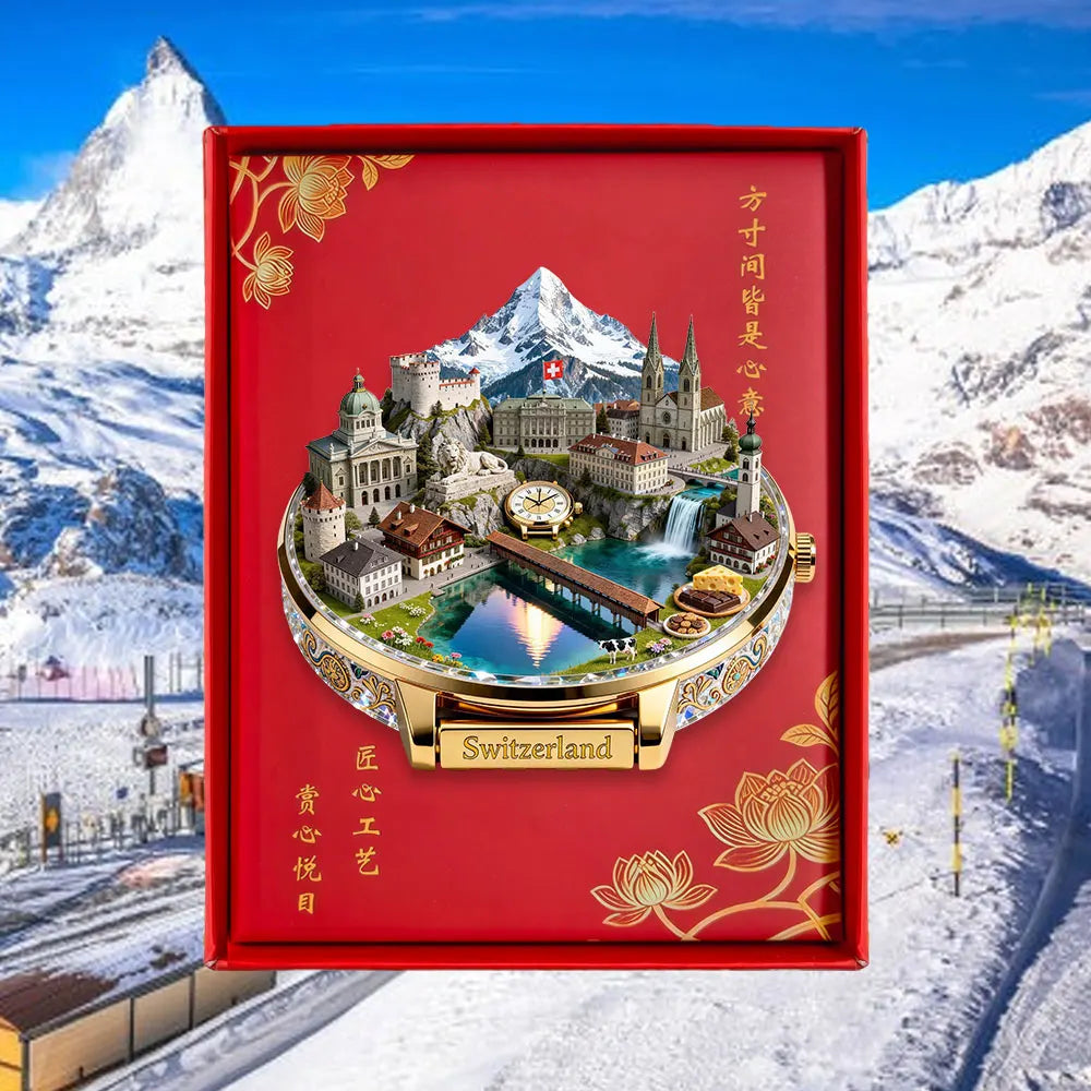 A red box containing an embossed metal fridge magnet depicting a scenic Swiss cityscape and mountains.