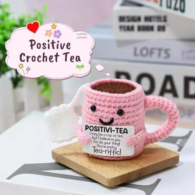 Pink crochet tea cup ornament with a smiling face and motivational text