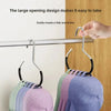 A close-up of a hat organizer rack with a large opening design hanging on a closet rod, displaying various colored hats.