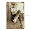 A sepia-toned portrait of an elderly man wearing a wide-brimmed hat and sitting in a wooden chair.