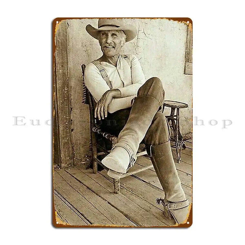 A sepia-toned portrait of an elderly man wearing a wide-brimmed hat and sitting in a wooden chair.