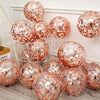 A collection of rose gold sequin balloons in various sizes displayed on a white wire rack.
