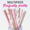 A multipack of pink and green striped paper drinking straws with star accents in a glass container.