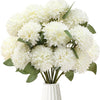 A bouquet of white artificial chrysanthemum flower balls with green leaves in a white vase.