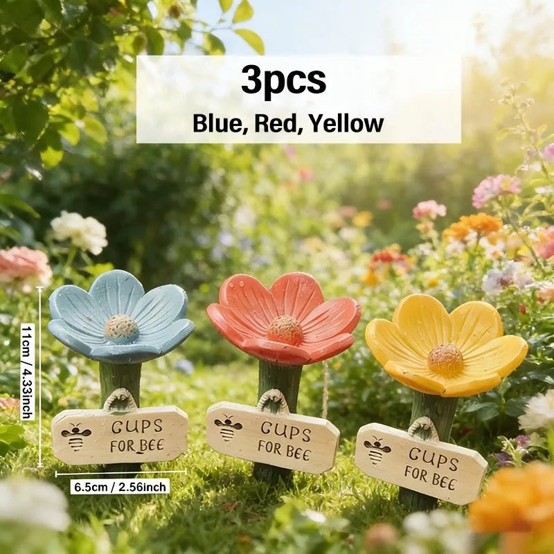 Three wooden signs in blue, red, and yellow colors for a bee watering station garden decoration