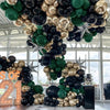 A dense balloon garland featuring black, gold, and green balloons decorating an indoor space.