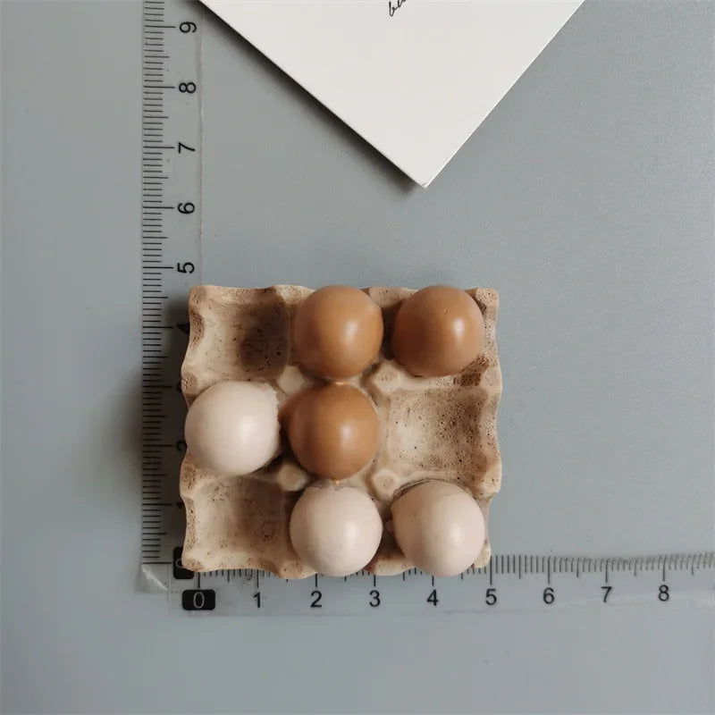 A set of six brown and white egg-shaped food magnets arranged on a measuring ruler.