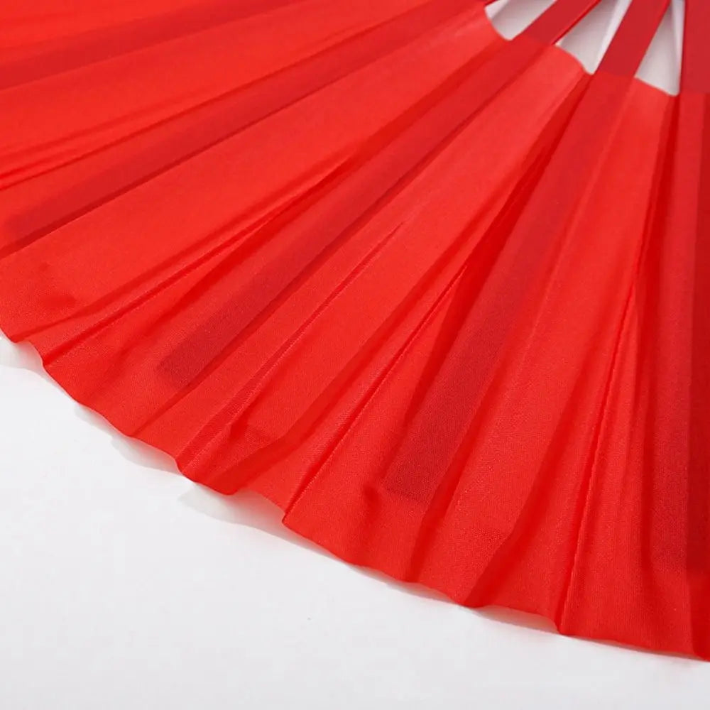 Red Tai Chi performance fan with durable plastic ribs shown from a close angle.
