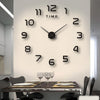 A modern wall clock with black numbers and hands displaying the time, mounted on a light-colored wall above a dining table.