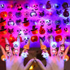 Hands holding glow-in-the-dark Halloween rings with flashing lights illuminating various spooky designs.
