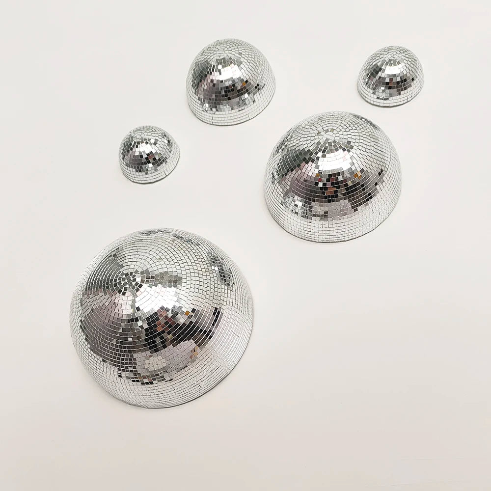 A collection of silver disco balls of various sizes arranged on a white background.
