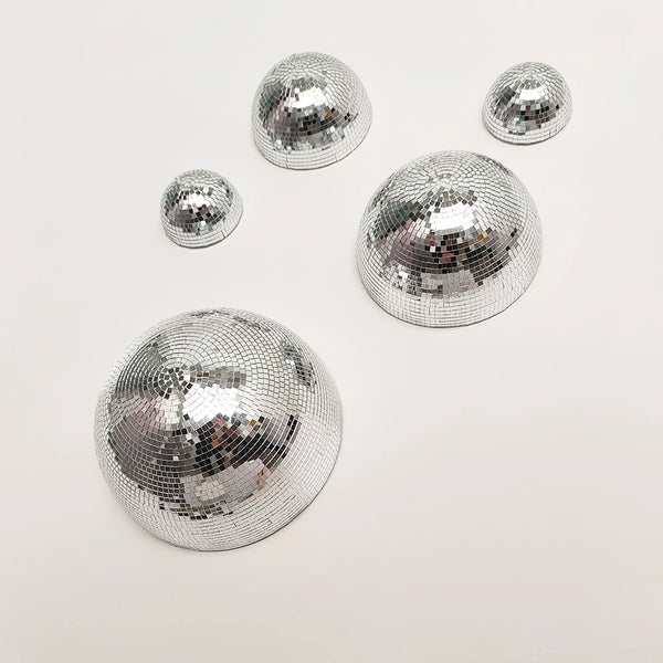A collection of silver disco balls of various sizes arranged on a white background.
