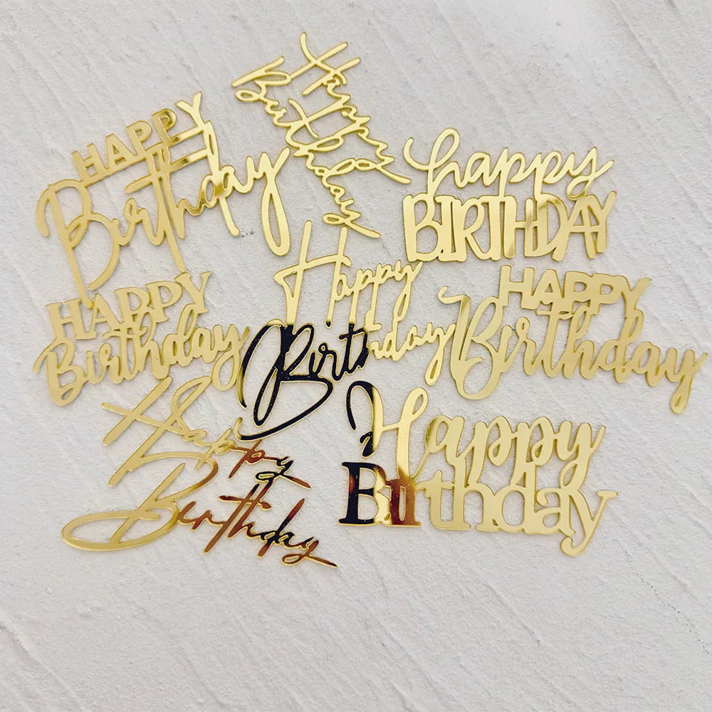 Eine Sammlung von acht goldenen Acryl-Buchstaben-Tortenaufsätzen mit handschriftlichen Botschaften.