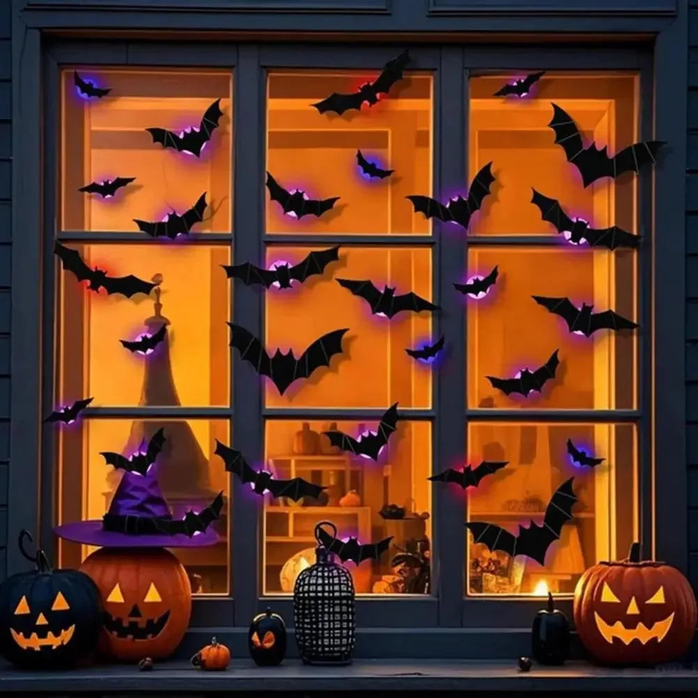 Exhibición de una ventana con luces nocturnas de murciélago y araña decorando el cristal y las calabazas.