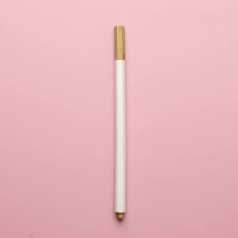 A vertical view of a transparent wax sealing bead with a gold cap against a pink background.