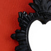 Black ornate wall pendant featuring a flame design against an orange background