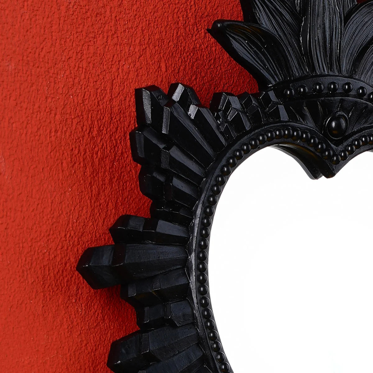 Black ornate wall pendant featuring a flame design against an orange background