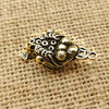A vintage brass Chinese fortune toad charm for wealth and prosperity resting on burlap fabric.