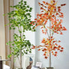 Artificial maple tree with silk leaves in shades of green and red displayed in a white planter.