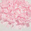 A pile of pink satin ribbon bows for gift wrapping and decor.