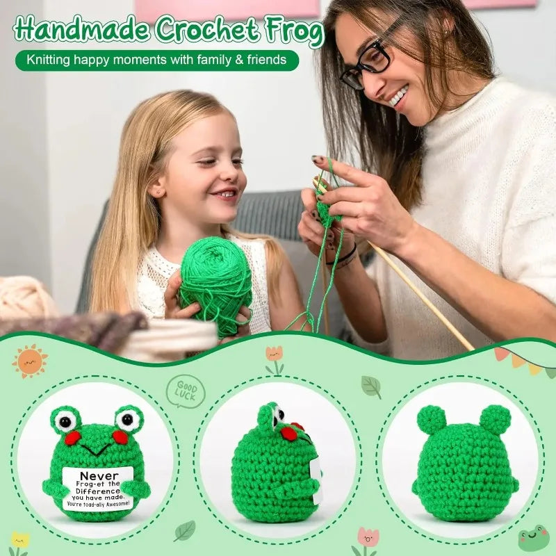 A woman is crocheting a green frog ornament with a young girl, showing the finished product.