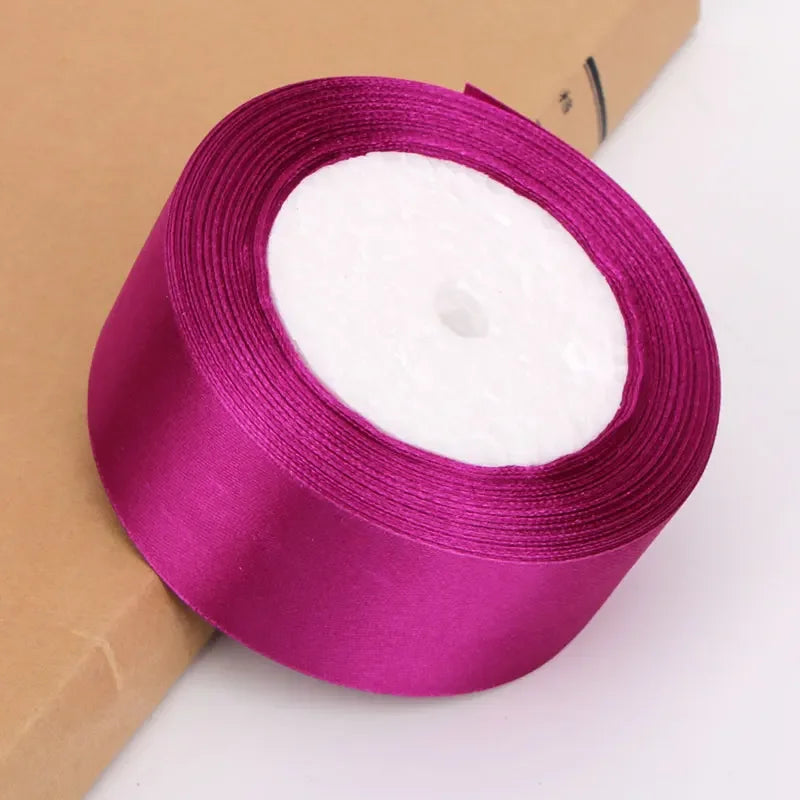 Roll of vibrant magenta satin ribbon with white filling for crafts and gift wrapping