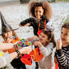 A group of children laughing while playing with a set of glow-in-the-dark Halloween bouncing balls.