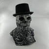 A realistic latex skull mask with a top hat and skeletal features, displayed against a light background.