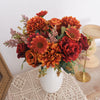 A vibrant bouquet of silk autumn roses and hydrangeas in shades of orange, rust, and deep red.