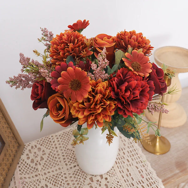 A vibrant bouquet of silk autumn roses and hydrangeas in shades of orange, rust, and deep red.