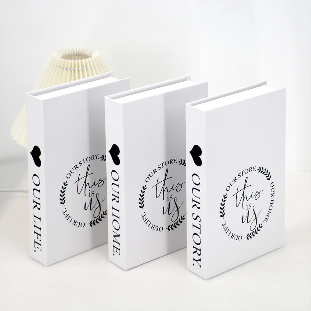 A set of three modern decorative fake books in white with black text and heart accents.