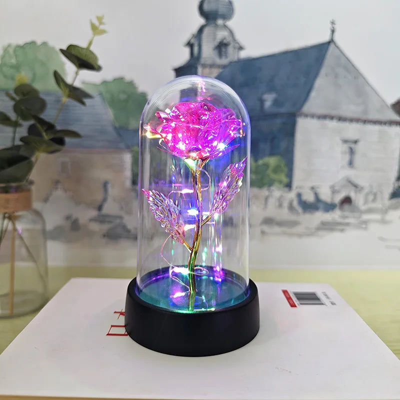 Rose de verre éternelle avec éclairage LED rose et violet sur une base noire.