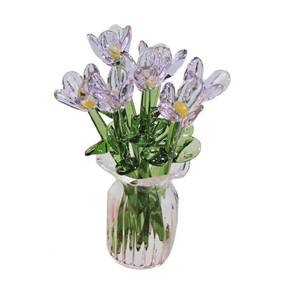 A bouquet of hand-blown glass purple and green flowers in a clear glass vase.