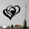 Black metal wall art featuring a silhouette of two interlocking hearts on a gray wall.