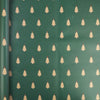 A roll of festive Christmas kraft wrapping paper featuring repeating small green pine trees on a muted green background.