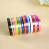 A roll of colorful satin balloon ribbons in various shades of pink, green, blue, and orange.