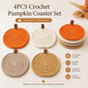 A set of four handmade crochet pumpkin coasters in various orange and beige tones for Halloween table decor