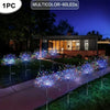 A row of multicolored LED fireworks lights illuminating a lawn and garden pathway at night.